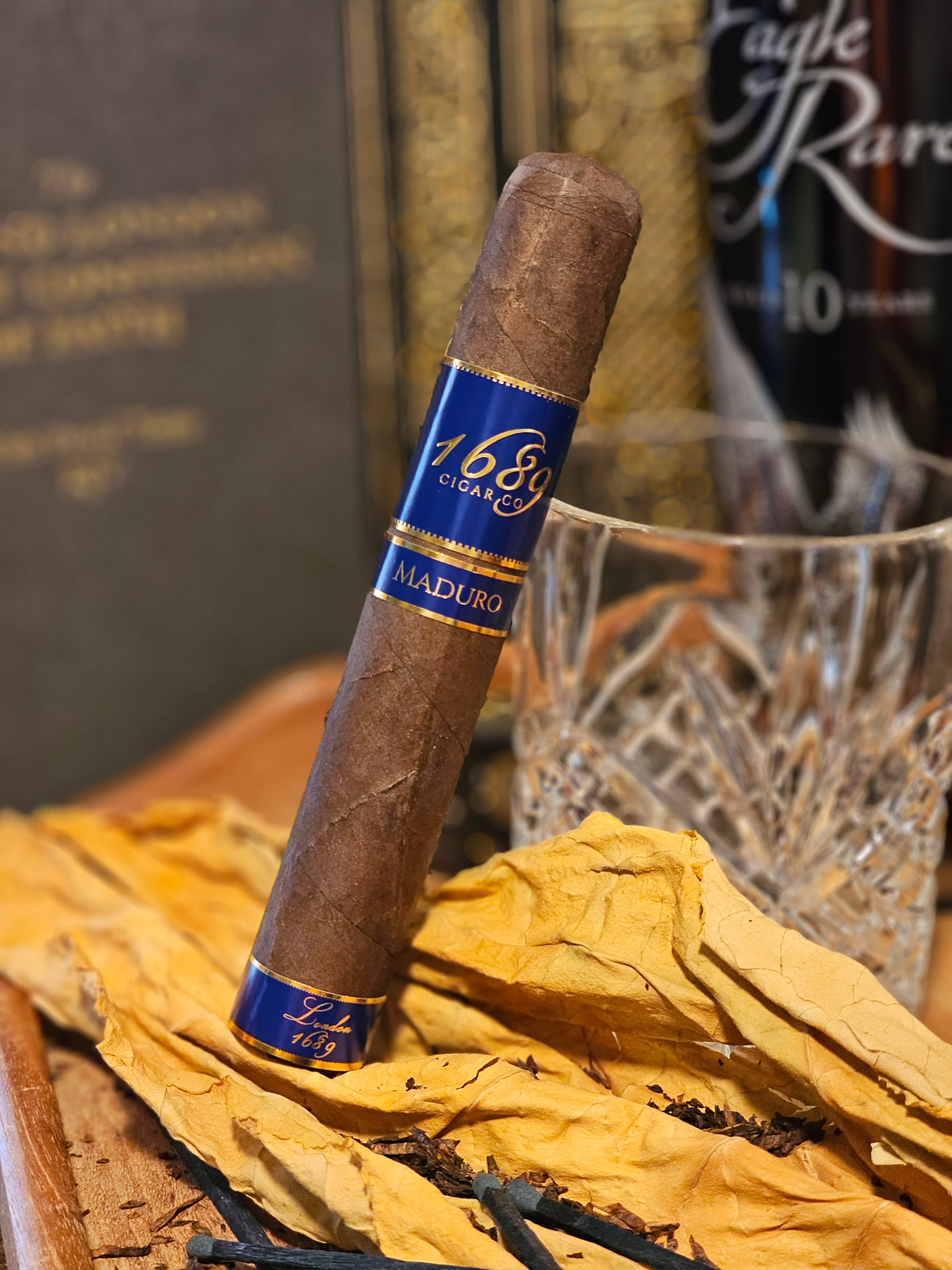 1689 London Maduro cigar presented among tobacco leaves and classic cigar-lounge details
